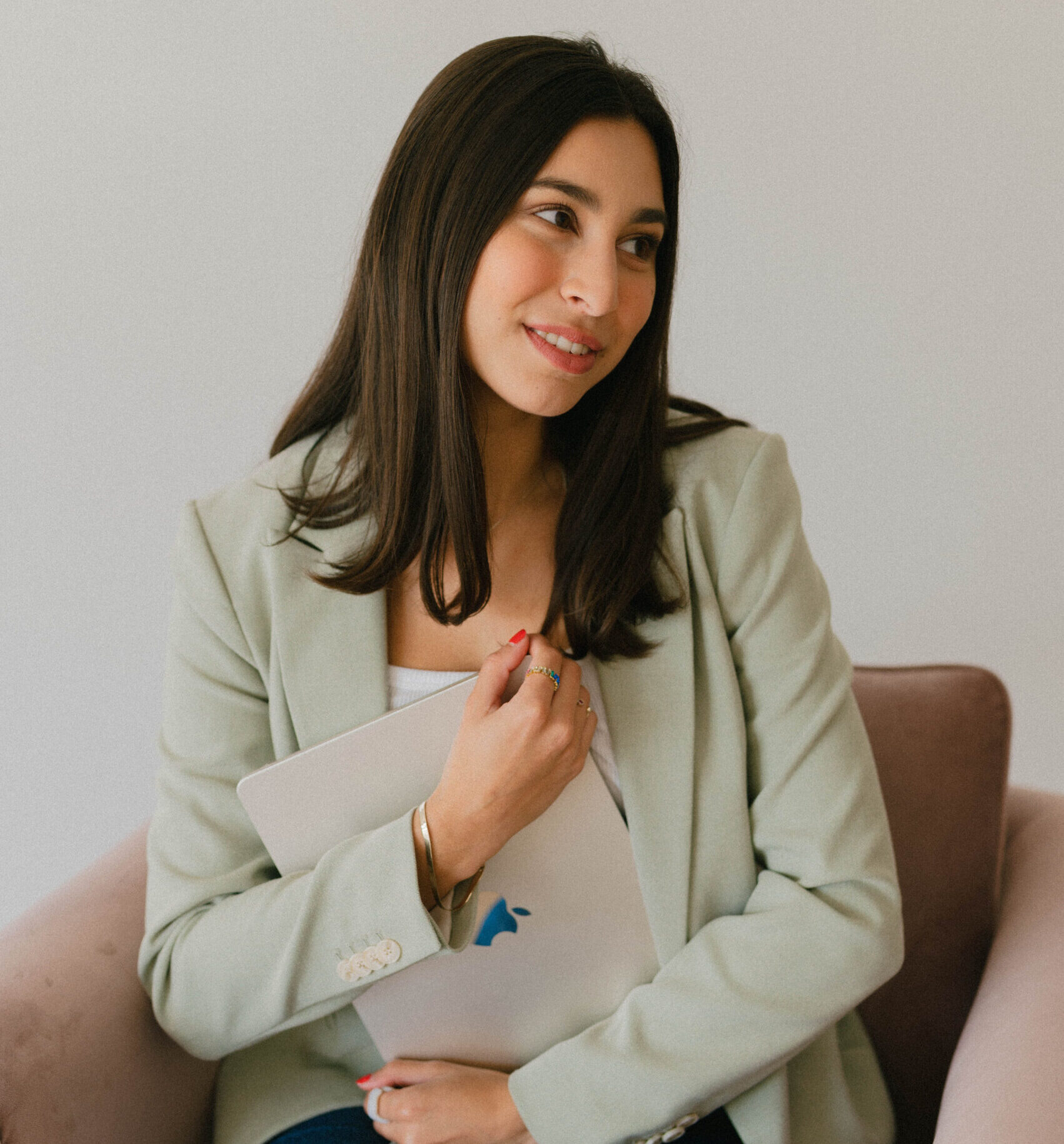 Young girl with green blazer holding a laptop business studio headshot